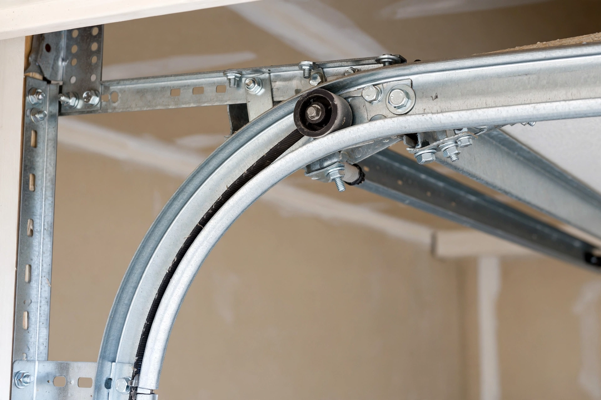 Garage door track curving with rollers engaged inside a residential garage